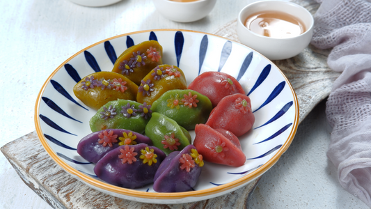 Colorful Korean songpyeon rice cakes decorated with floral designs on a traditional plate